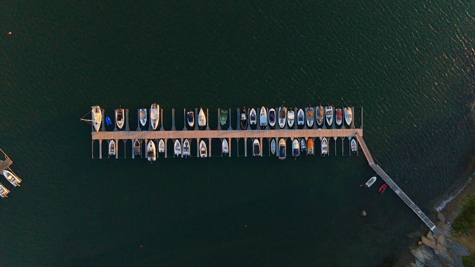 Berthed boats along a long timber pier