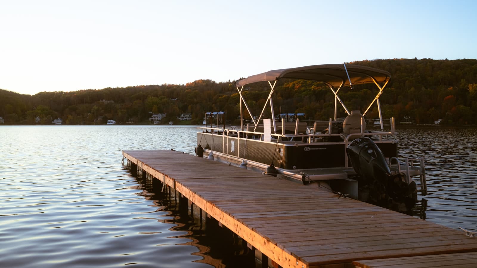 Timber jetty with a pontoon boat moored alongside at dusk